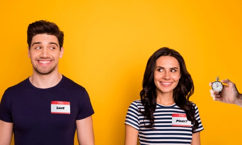 Male brunette in black t-shirt and female short-haired brunette in black and white striped shirt about to go on a speed date